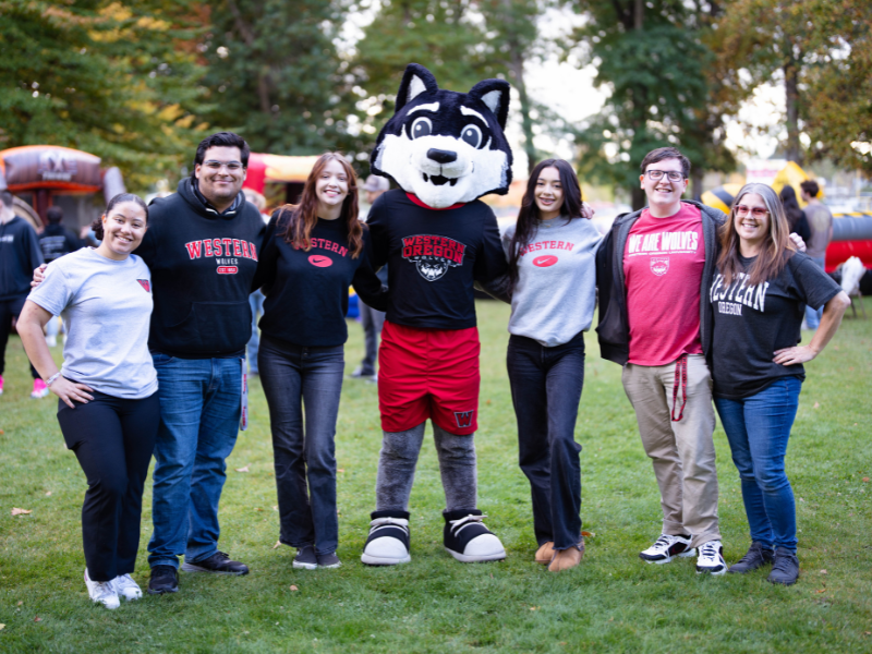 Wolfie Mascot on turf with 6 wou students posing for a group portrait.