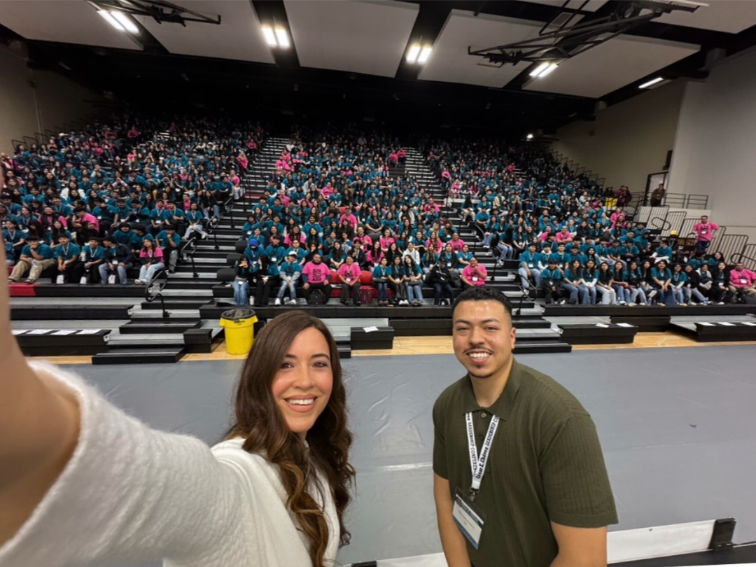 CECLC PR Photo of two students taking a selfie with a crowd behind them