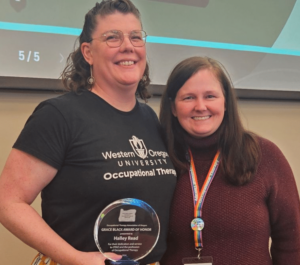 Two women holding an award