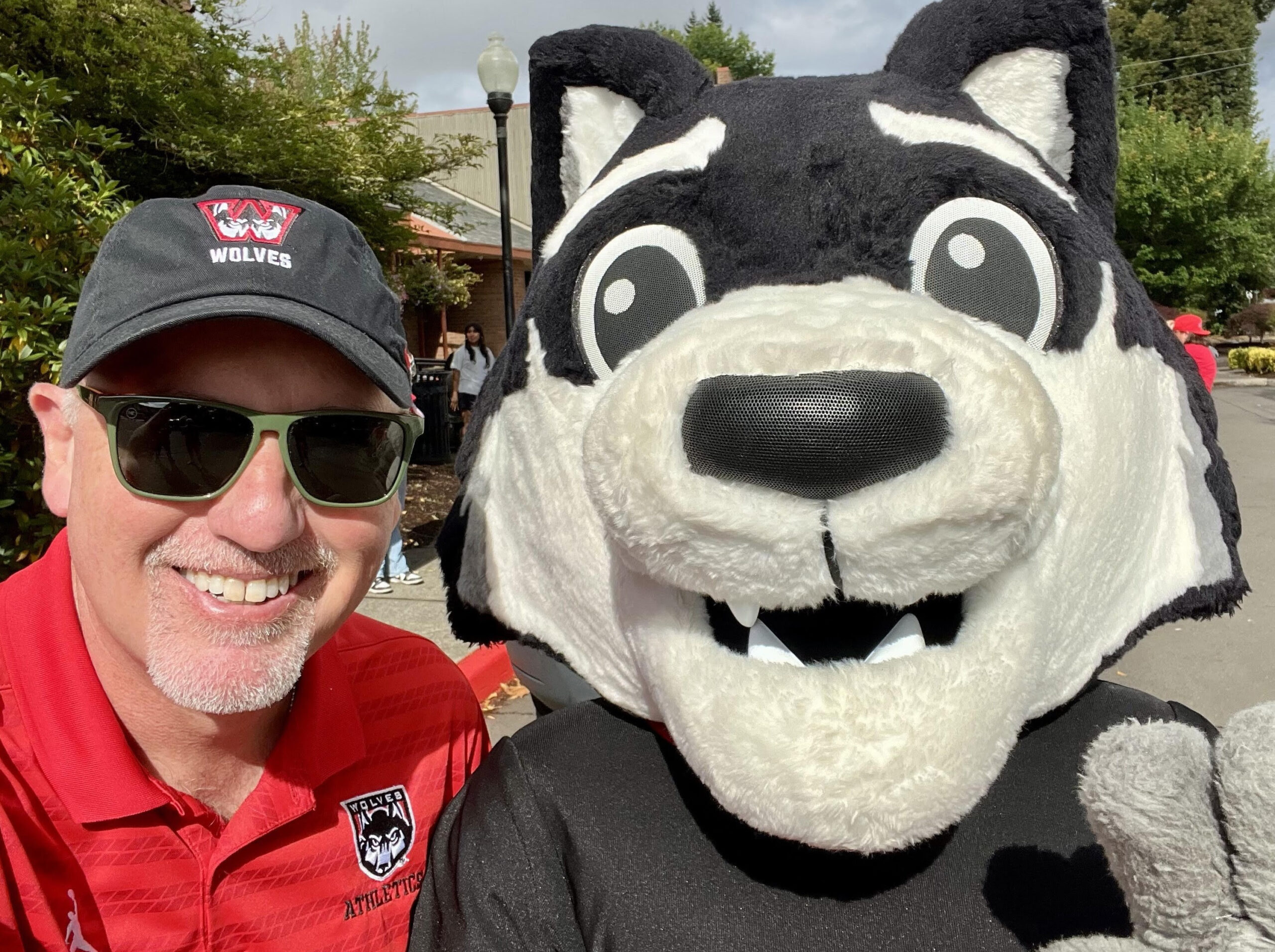 Man taking a selfie with a large crowd behind him
