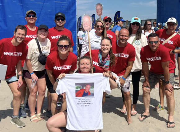 peter_wolves People wearing red shirts smiling with a wolf mascot