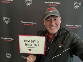 Man taking a selfie with a large crowd behind him