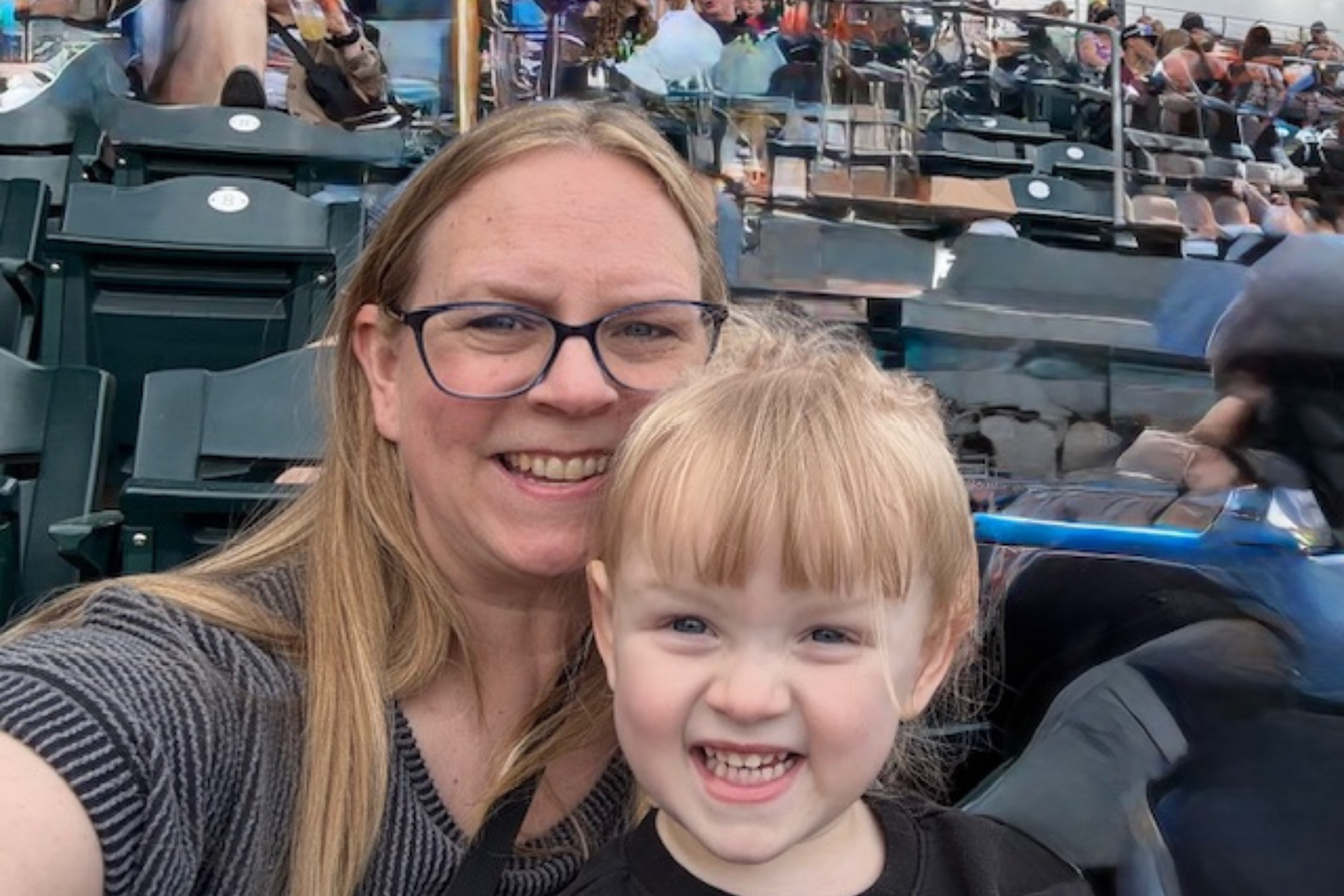 Dr. Cheryl Beaver An selfie of Dr. Cheryl Beaver and a child sitting on her lap in outdoor stadium seating.