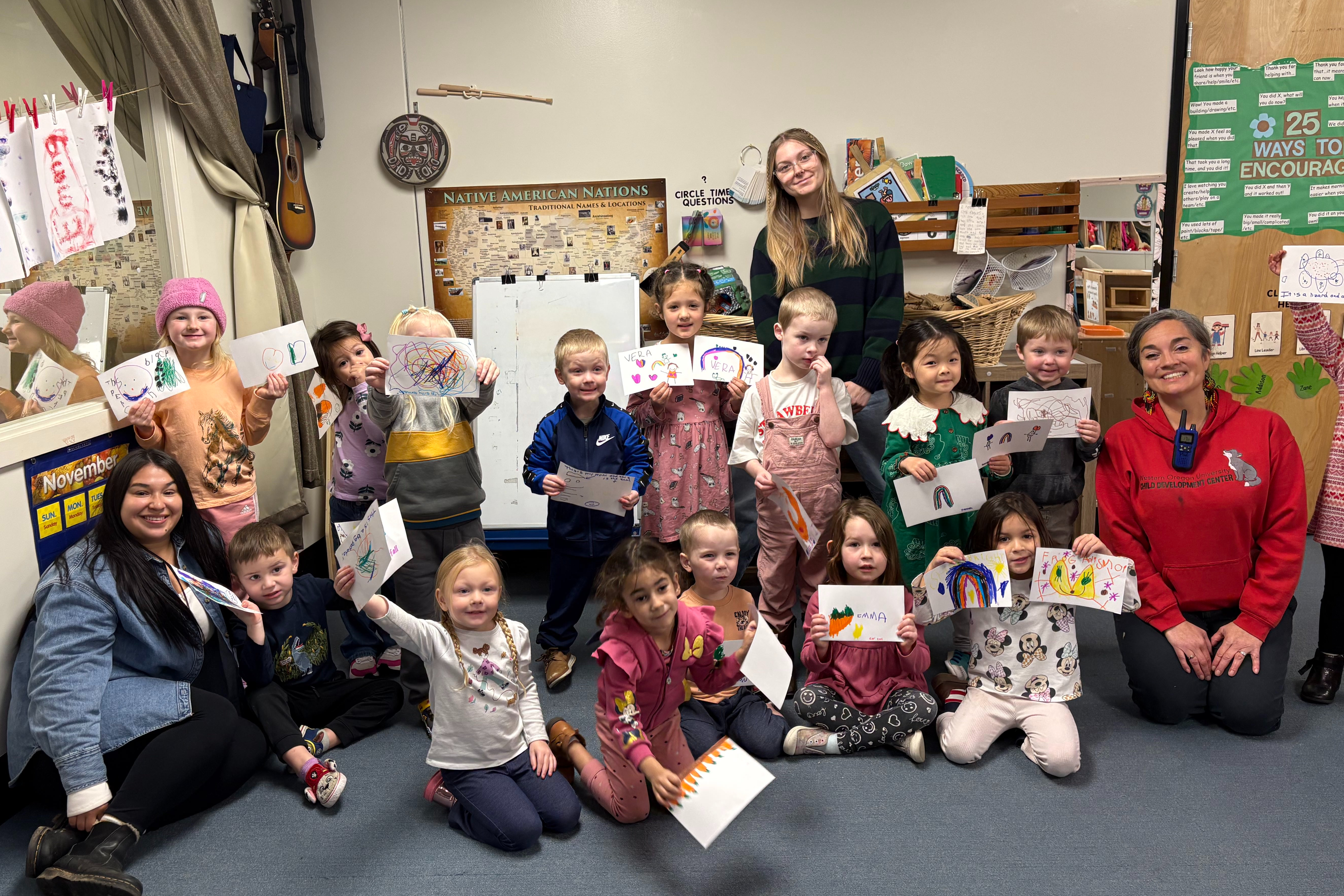 Classroom of children holding up the cards they made for foster children.