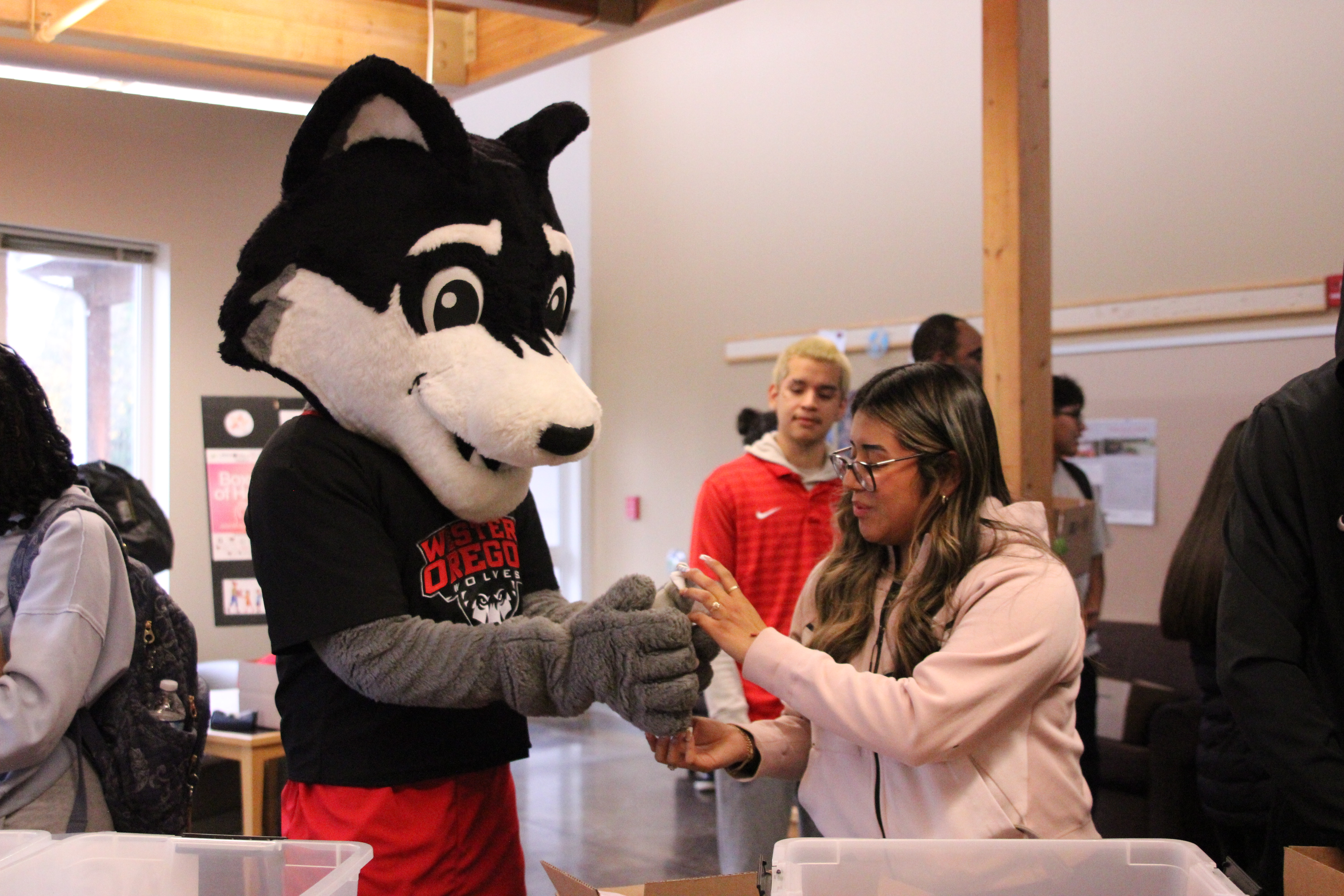 Wolfie making a box with a WOU student.