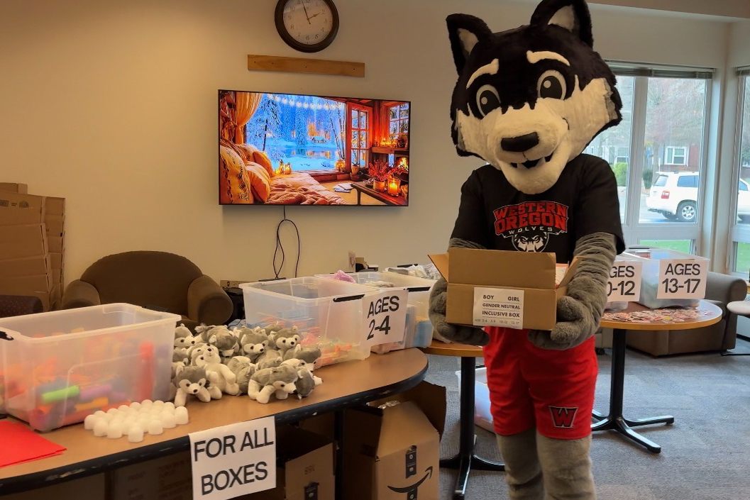 Wolfie holding a care box next to the care box creation station.