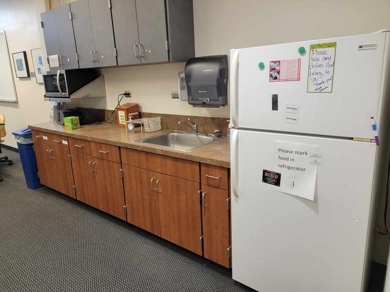 Kitchenette with fridge, sink, and microwave.