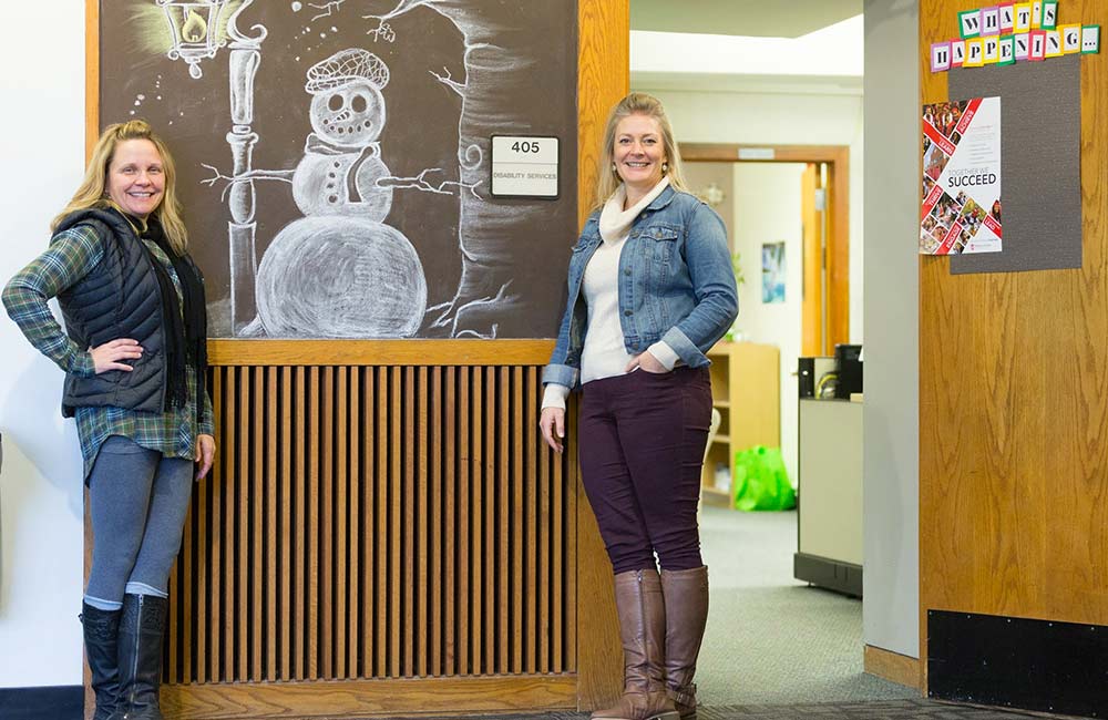Director Malissa Larson and Administrative Program Specialist Louann Casares standing outside entrance of Office of Disability Services Office